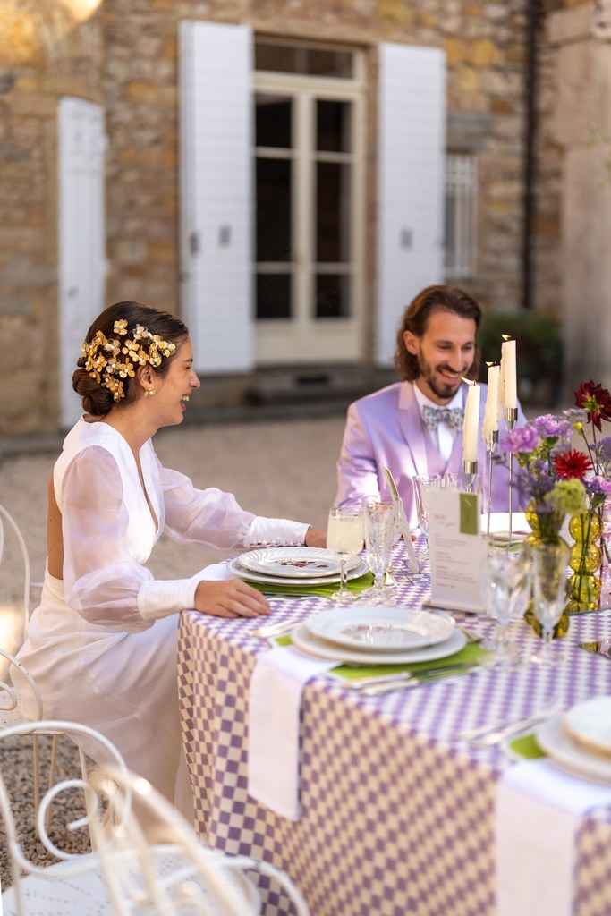 Couple assis à la table dressée pour le shooting d'inspiration mariage "HISTOIRE DU TEMPS". La nappe vichy est de couleurs blanche et lavande. De jolis vases bulbes verticaux de couleurs verte, lavande, bordeaux agrémentés de fleurs dans les mêmes tons ainsi que des bougeoirs argentés de différentes tailles agrémentent le centre de table. La vaisselle vintage fleurie dans les tons blanc, lavande et bordeaux de Maison 1891 vient rehausser cette table. Les verres anciens (eau, vin et champagne) sont en cristal. Les 6 couverts par convive sont en métal argenté. C'est une table des grands jours, pour des évènements élégants et chics.
Crédit photo : @ameliecharlet.photographie
Publié prochainement sur @lasoeurdelamariee
La Team HISTOIRE DU TEMPS :
Wedding planner & Direction artistique : @carrement_mariage
Lieu de réception : @domainedetourieux
Photographes : @ameliecharlet.photographie @beajouy.photographe
Vidéaste : @alexandrasch.films
Mise en beauté - MUAH : @virginie_dsfn
Assistante MUAH : @camille.muah
Papeterie : @jodieatelier
Fleuriste : @jacintheetlilas
Paper florist : @brindesev
Wedding cake : @loongateaux
Créatrice robe & combinaison des mariées : @atelier_mahie
Accessoires & boucles d’oreille : @constella.design
Alliances, bagues & pendentif : @chavanybijouterie
Costume Timothé (Lilas) : @leguillou_boutiques
Costume Giuseppe (Bleu nuit) : @surmon31
Modèles Alexandra & Timothé : @alexandra_parm @timo_meniere @modelcouple_timo_alex
Modèles Sylvie & Giuseppe : @sylvie_gotti @giuseppemodel
Location voiture : @les.4coeurs
Livre d’or audio : @majoliemessagerie
Location vaisselle & décoration vintage : @vintage.maison1891
Créatrice de contenu : @agencestories